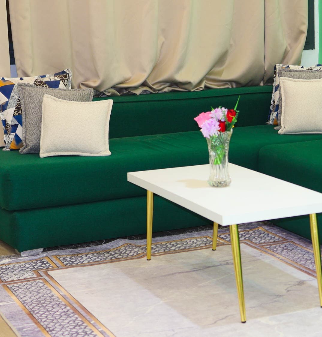 Appartement 5 — salon avec canapé vert émeraude et table basse dorée